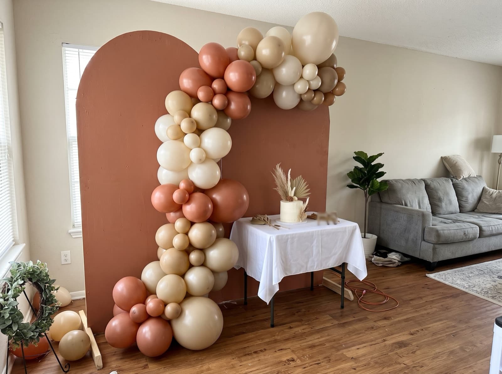 Half balloon arch swooping over a cake table