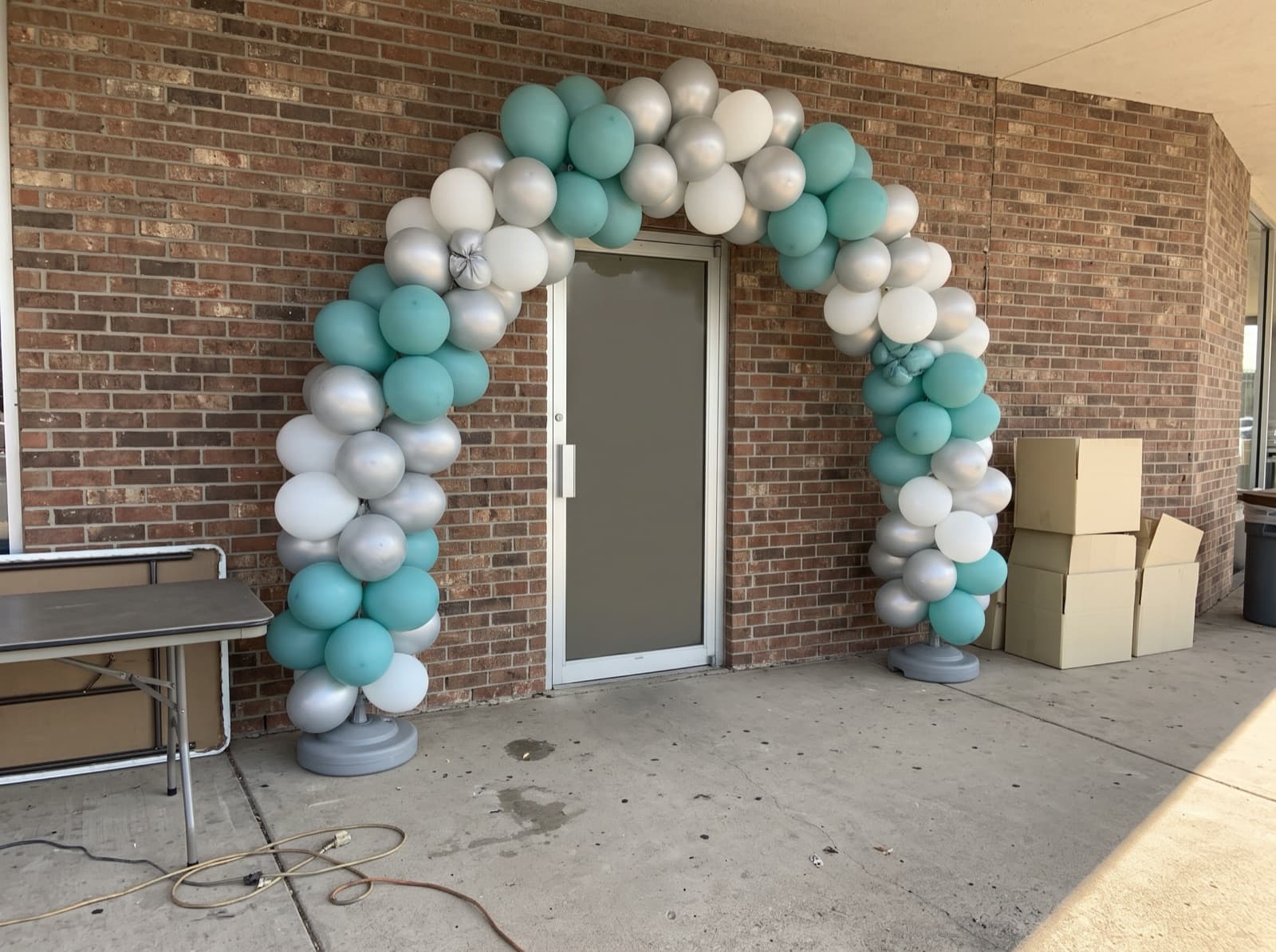 Large balloon arch over a storefront entrance